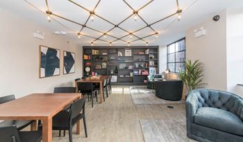 Coworking lounge with geometric ceiling lighting and bookshelves
